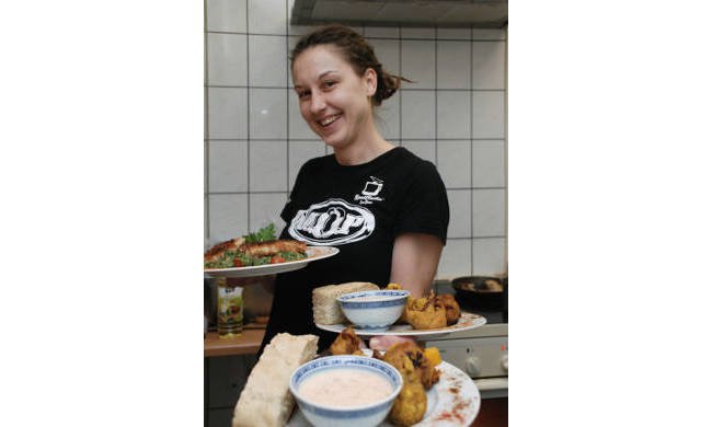 Frau mit Tellern voll Essen in der Hand